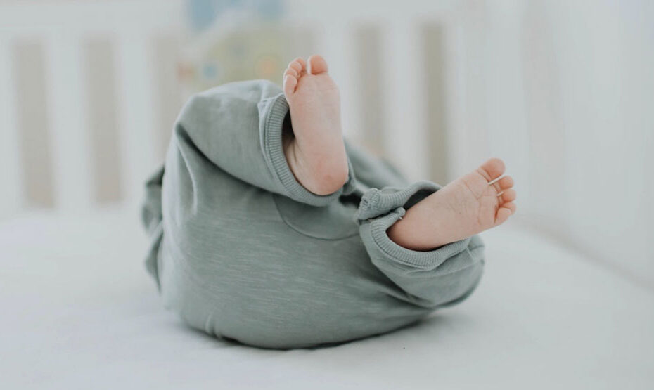 Baby in cradle, shows feet